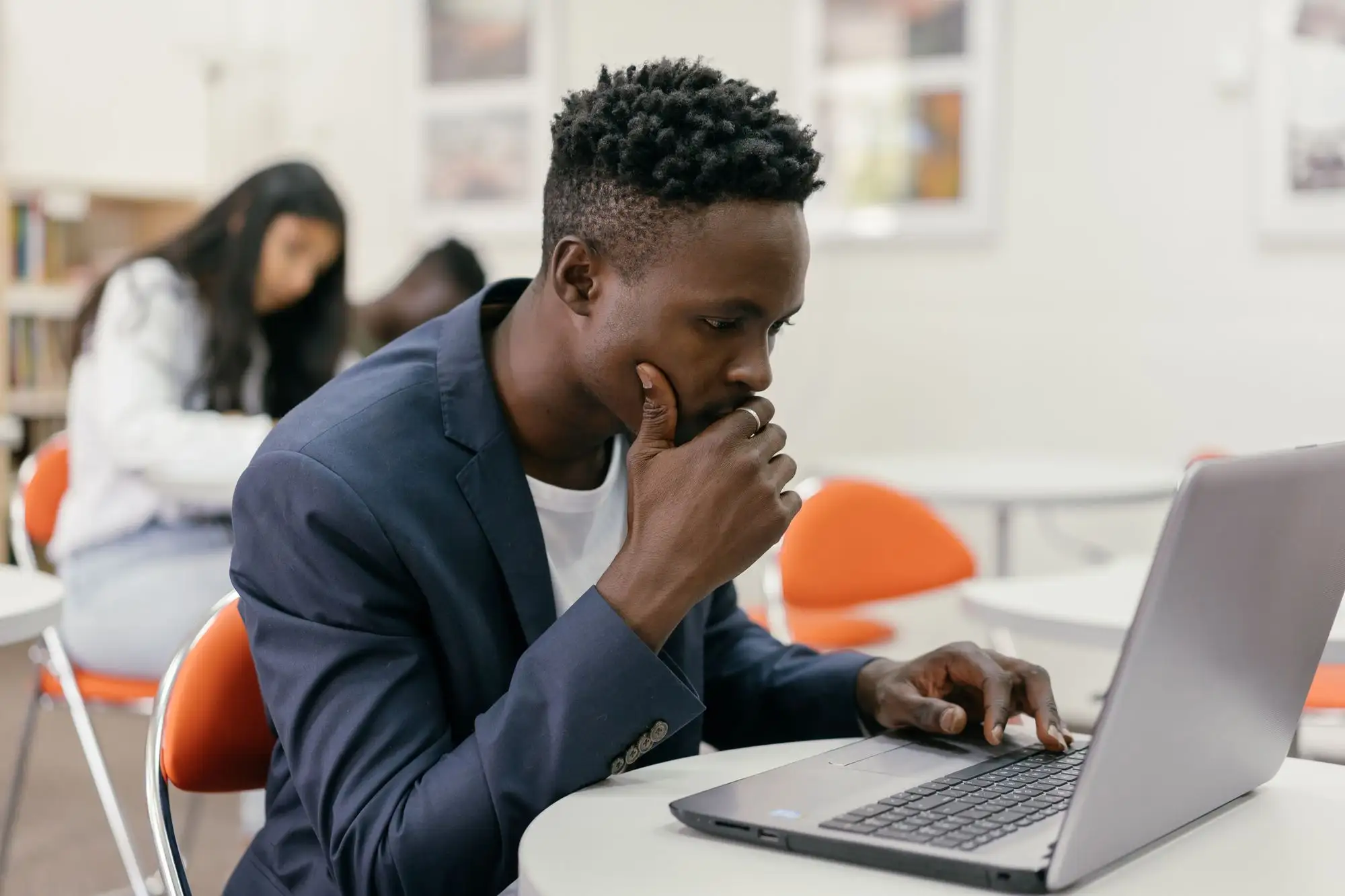 A student thinks over a problem at his laptop.