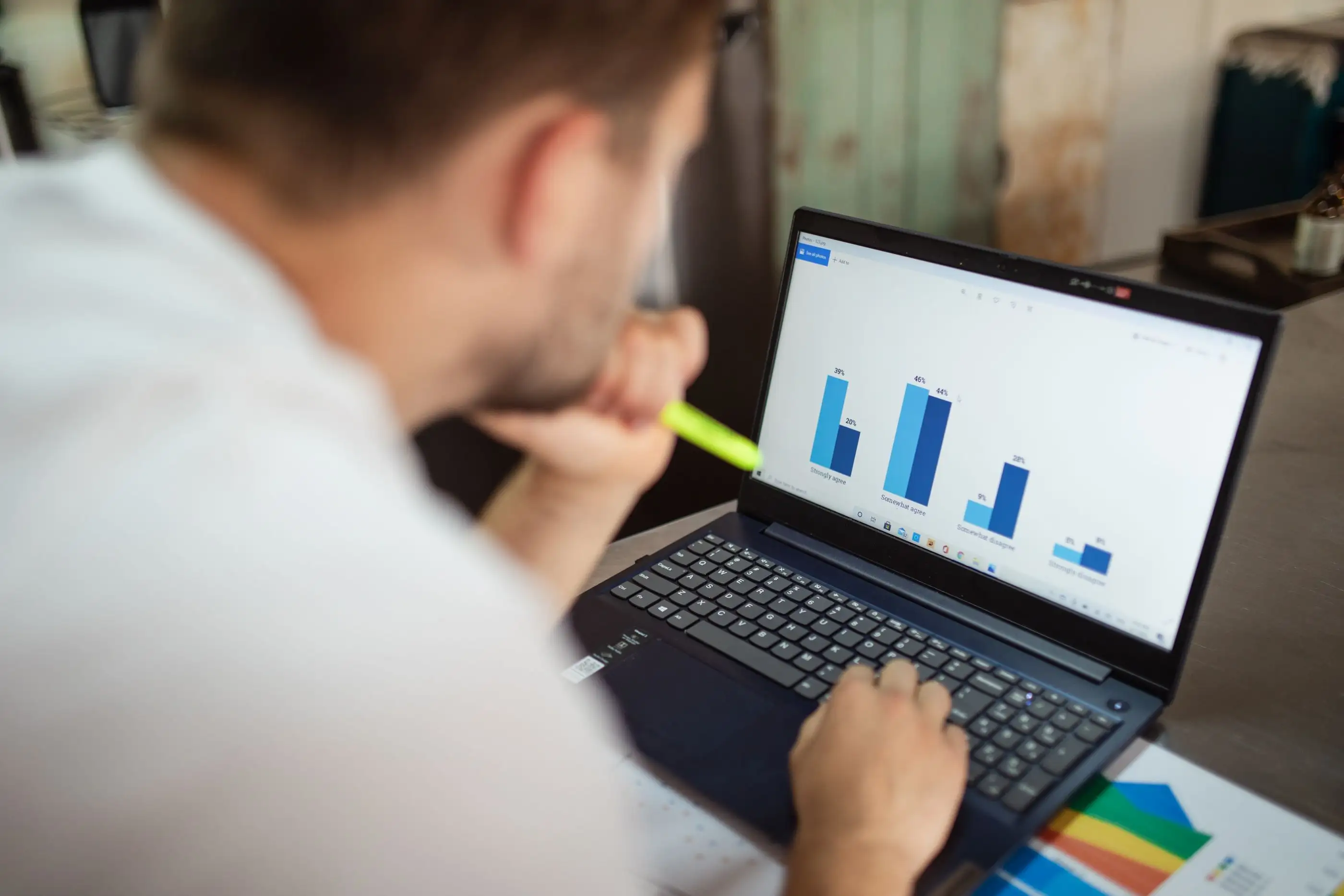 A man studies a bar chart on his laptop.