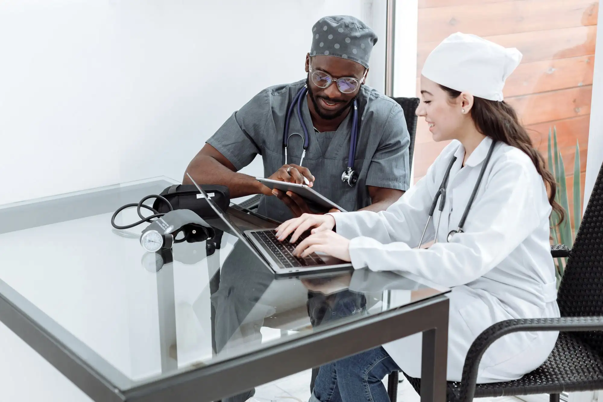 Two clinicians work together at a laptop.